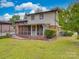 View of the home's back exterior with a large screened-in porch and carport on a wet day at 2213 Milton Rd, Charlotte, NC 28215
