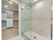 Bathroom with a glass shower door and a view into the walk in closet with white shelving at 2401 Euclid Ave # 207, Charlotte, NC 28203