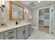 Bright bathroom featuring gray cabinets, a wood framed mirror, white countertops, and a walk-in closet at 2401 Euclid Ave # 207, Charlotte, NC 28203