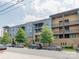 Exterior view of a multi-level condo building with parking in front and shade trees at 2401 Euclid Ave # 207, Charlotte, NC 28203