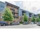 Exterior view of a multi-level condo building with parking in front and shade trees at 2401 Euclid Ave # 207, Charlotte, NC 28203