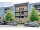 Exterior view of a multi-level condo building with parking in front and shade trees at 2401 Euclid Ave # 207, Charlotte, NC 28203