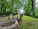 Charming backyard featuring a stone fire pit and lush lawn, ideal for outdoor entertainment at 2437 Woodleigh Dr, Gastonia, NC 28056