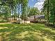 Expansive backyard featuring lush green grass, mature trees, a fence, and the back of the house at 2437 Woodleigh Dr, Gastonia, NC 28056