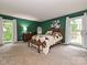 Spacious bedroom featuring hardwood furniture, carpet floors, and sun-filled windows at 2437 Woodleigh Dr, Gastonia, NC 28056