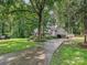 Inviting home with a long driveway and mature trees, providing a picturesque curb appeal at 2437 Woodleigh Dr, Gastonia, NC 28056