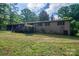 A brick home with a wooden deck featuring a spacious backyard with lush green grass at 2871 Loviee Rd, Lincolnton, NC 28092