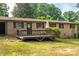 Brick home with a wooden deck including an umbrella and seating surrounded by green grass at 2871 Loviee Rd, Lincolnton, NC 28092