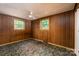 An empty bedroom featuring paneled walls, patterned carpet and natural light from two windows at 2871 Loviee Rd, Lincolnton, NC 28092