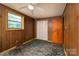 A bedroom featuring paneled walls, patterned carpet, window, closet, and a ceiling fan at 2871 Loviee Rd, Lincolnton, NC 28092
