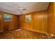 Bedroom with patterned carpet, wood-paneled walls, and two windows providing natural light at 2871 Loviee Rd, Lincolnton, NC 28092