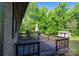 Wooden deck with outdoor seating surrounded by lush greenery and trees at 2871 Loviee Rd, Lincolnton, NC 28092