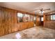 Spacious living room with wood paneling, ceiling fan, and doorway leading to the kitchen at 2871 Loviee Rd, Lincolnton, NC 28092