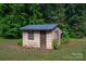 Rustic outbuilding with a simple wooden door and frame windows surrounded by green foliage at 2871 Loviee Rd, Lincolnton, NC 28092