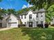 Classic two-story home with a white brick exterior, attached garage, and meticulously manicured front lawn at 3626 Cole Mill Rd, Charlotte, NC 28270