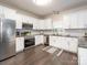 Bright kitchen with white cabinets, stainless steel appliances, granite countertops, and hardwood flooring at 3626 Cole Mill Rd, Charlotte, NC 28270