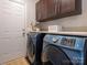 Functional laundry room with dark cabinets, countertop space and modern front loading washer and dryer at 3626 Cole Mill Rd, Charlotte, NC 28270