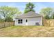 The backyard features a well-maintained lawn, privacy fence, and a home with gray siding and a gray roof at 401 Groves St, Lowell, NC 28098
