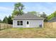 The backyard features a well-maintained lawn, privacy fence, and a home with gray siding and a gray roof at 401 Groves St, Lowell, NC 28098