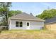 The backyard features a well-maintained lawn, privacy fence, and a home with gray siding and a gray roof at 401 Groves St, Lowell, NC 28098