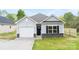 Charming one-story home with light gray siding, black shutters, and a one-car garage at 401 Groves St, Lowell, NC 28098