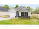 Charming one-story home with light gray siding, black shutters, and a one-car garage at 401 Groves St, Lowell, NC 28098