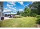 Expansive backyard featuring a stone patio, built-in seating, lush lawn, and mature trees at 4016 Spring Cove Way, Belmont, NC 28012