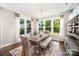 Elegant dining room with large windows, a rustic table with bench seating, and stylish decor at 4016 Spring Cove Way, Belmont, NC 28012
