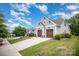 Attractive home featuring a well-kept lawn, two-car garage, and charming exterior details under a bright blue sky at 4016 Spring Cove Way, Belmont, NC 28012
