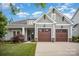 Inviting home showcasing a two-car garage, green lawn, and appealing facade with craftsman details at 4016 Spring Cove Way, Belmont, NC 28012