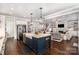 Modern kitchen features a central island with a farmhouse sink, pendant lighting, and stainless steel appliances at 4016 Spring Cove Way, Belmont, NC 28012