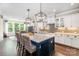 Well-lit kitchen offers an island with barstools, white cabinets, and modern appliances at 4016 Spring Cove Way, Belmont, NC 28012