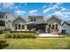 A charming outdoor patio features an outdoor kitchen, seating, umbrellas and well-manicured flower beds at 4016 Spring Cove Way, Belmont, NC 28012