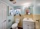Vintage bathroom with a white toilet, sink and vanity, plus a window with decorative curtains at 4325 Wolf Pond Rd, Monroe, NC 28112