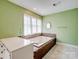 Large soaking tub with tile surround and a view from the large window at 4325 Wolf Pond Rd, Monroe, NC 28112