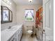 Bright bathroom featuring a vanity, patterned shower curtain and a window with decorative curtains at 4325 Wolf Pond Rd, Monroe, NC 28112