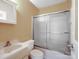 Bathroom with a shower-tub combo featuring a glass sliding door and a white vanity at 4325 Wolf Pond Rd, Monroe, NC 28112
