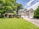 Charming two-story home with a three-car garage and a large, well-maintained front lawn surrounded by mature trees at 4325 Wolf Pond Rd, Monroe, NC 28112