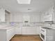 Classic white kitchen with matching appliances, countertops and cabinets, plus hardwood floors for warmth and style at 4325 Wolf Pond Rd, Monroe, NC 28112