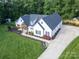 Aerial view of a charming home with a well-manicured lawn, a covered porch, and fresh landscaping at 518 Maynard Farm Ln, Stanley, NC 28164