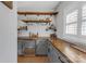 Custom bar area with wooden countertops, gray cabinets, open shelving, mini fridge, and unique industrial accents at 518 Maynard Farm Ln, Stanley, NC 28164