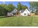 Beautiful white farmhouse with a manicured lawn and inviting front porch at 518 Maynard Farm Ln, Stanley, NC 28164