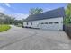 Spacious white garage with a double door and black hardware complemented by a long driveway and manicured landscaping at 518 Maynard Farm Ln, Stanley, NC 28164