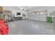 Spacious garage with epoxy flooring, storage racks, TV, and a bike at 518 Maynard Farm Ln, Stanley, NC 28164