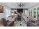 Bright living room with a stone fireplace, built-in shelves, and modern ceiling fan at 518 Maynard Farm Ln, Stanley, NC 28164