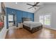 Spacious main bedroom with blue accent wall, vaulted ceilings, hardwood floors, and a view into the ensuite bathroom at 518 Maynard Farm Ln, Stanley, NC 28164