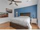 Serene main bedroom featuring hardwood floors, blue accent wall, ceiling fan, and ample natural light at 518 Maynard Farm Ln, Stanley, NC 28164