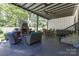 Outdoor patio with a stone fireplace, ample seating, dining table, and grill at 518 Maynard Farm Ln, Stanley, NC 28164