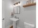 Charming powder room featuring a pedestal sink, modern fixtures, and decorative mirror at 518 Maynard Farm Ln, Stanley, NC 28164
