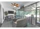 Cozy screened porch with comfortable seating, ceiling fan, and outdoor television at 518 Maynard Farm Ln, Stanley, NC 28164